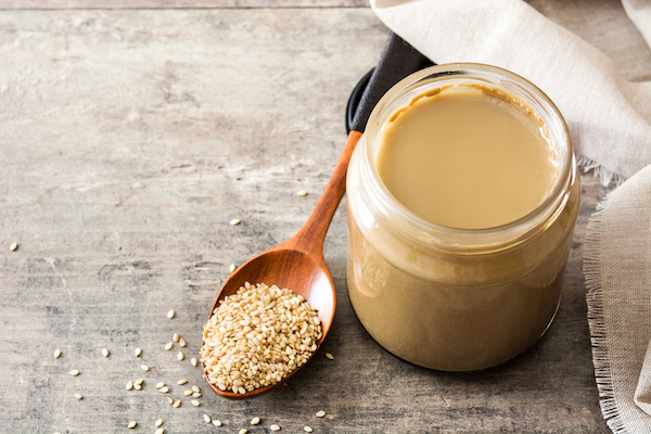 Tahini,And,Sesame,Seeds,On,Wooden,Table.,Copyspace