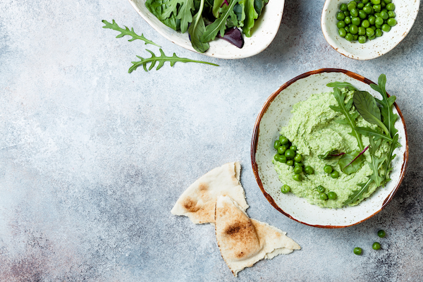 Green,Pea,Hummus,Spread,Or,Dip,With,Mix,Salad,Leaves.