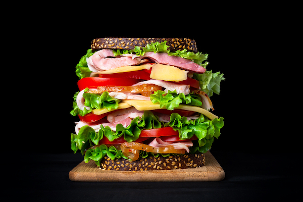Huge,Appetizing,Sandwich,On,A,Black,Background.