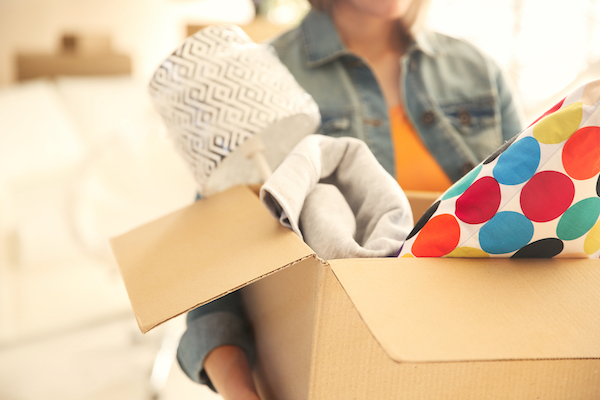 Young,Woman,Holding,Open,Cardboard,Box,With,Things,For,Moving