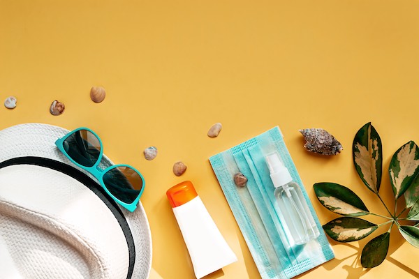 Flat lay concept of travel during coronavirus pandemic. Yellow background with place for text and accessories for flying holiday