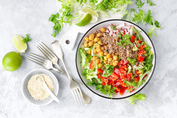 Healthy and delicious bowl with buckwheat and salad of chickpea, fresh pepper and lettuce leaves. Dietary balanced plant-based food. Vegan and vegetarian dish. Top view. Flat lay