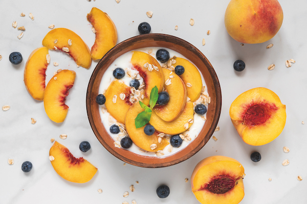 Bowl,Of,Oats,With,Yogurt,,Fresh,Peaches,,Blueberries,And,Mint