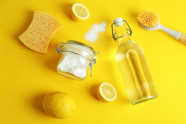 Cleaning concept with eco friendly cleaning tools and lemons on yellow background