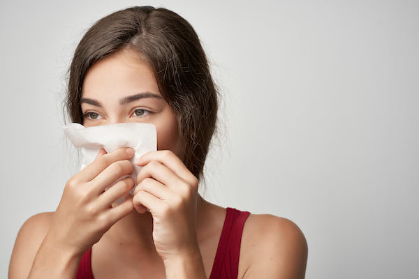 cold woman with headscarf runny nose health close-up