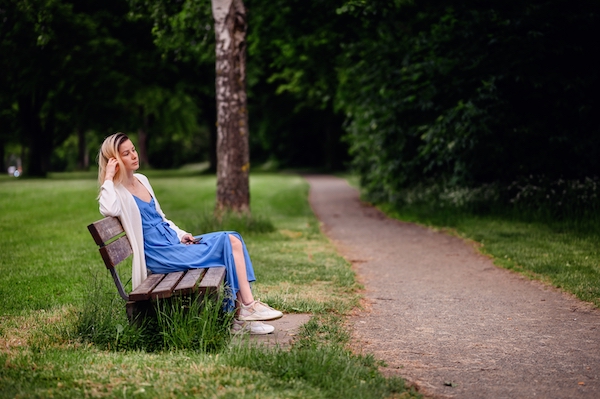 young-blonde-girl-in-blue-sundress-sitting-on-wood-2023-11-27-05-30-32-utc