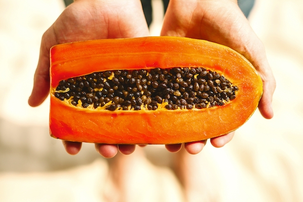 a-man-holds-half-a-papaya-in-his-hands-2023-11-27-05-19-46-utc