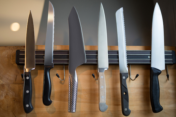 Set of kitchen knives hanging on the wall