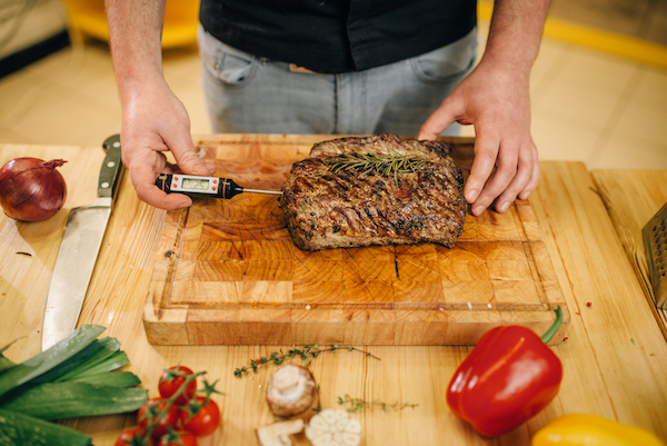 Chef at the pan with roasted meat and vetables