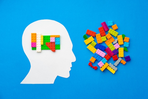 Papercut silhouette of human head with colorful constructor pieces