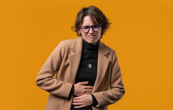 Businesswoman squeezing belly with hands. abdominal pain, suffering stomach ache