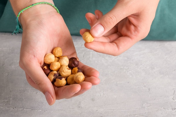 Handful of dried hazelnuts in female hands. Healthy snack and healthy eating
