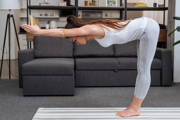 young woman practicing yoga pose at home in living room