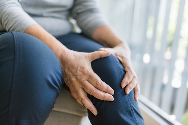 Senior woman holding her painful knee