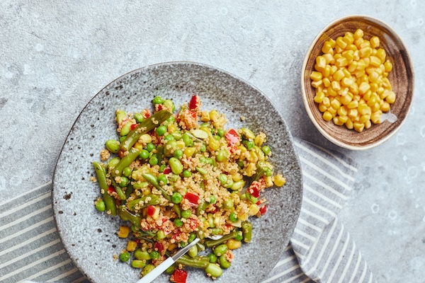 Quinoa salad with green beans, corn, red bell peppers, peas and soybeans. Useful vegetable mix