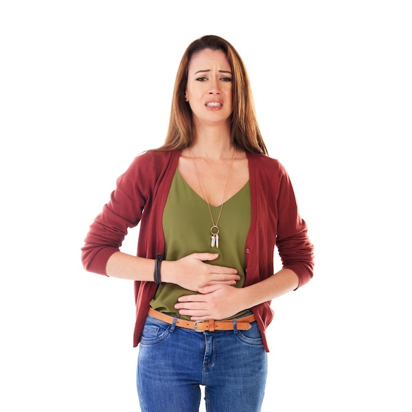Studio shot of a young woman holding her stomach and feeling unwell isolated on white