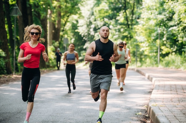 Joggers are on the road. Group of runners are together outdoors