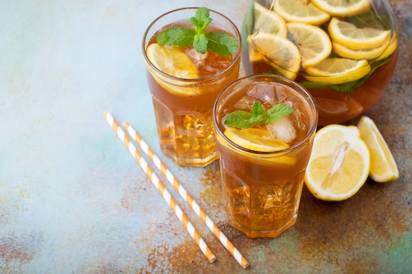 Traditional iced tea with lemon, mint and ice in tall glasses. Two glasses with cool summer drink