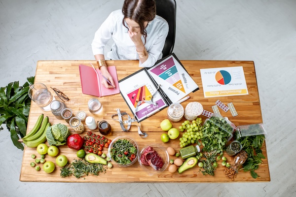 Writing a diet plan on the table full of healthy food
